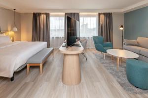 a hotel room with a bed and a living room at Radisson Hotel Kaunas in Kaunas