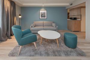 a living room with a couch and two chairs and a table at Radisson Hotel Kaunas in Kaunas