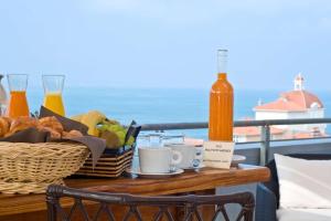 einen Tisch mit einem Korb mit Speisen und Getränken auf dem Balkon in der Unterkunft Radisson Blu Hotel Biarritz in Biarritz