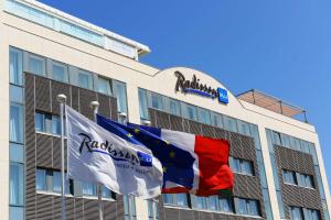 een gebouw met de vlag van de Russische federatie en de vlag van de Franse bij Radisson Blu Hotel Biarritz in Biarritz