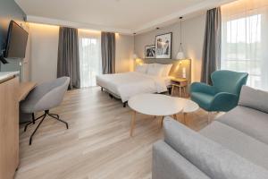 a hotel room with a bed and a couch at Radisson Hotel Kaunas in Kaunas