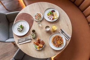 a wooden table with plates of food on it at Radisson Hotel Kaunas in Kaunas