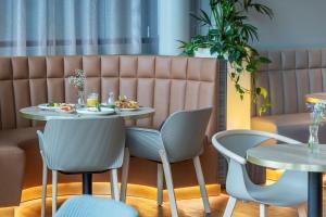 a dining room with two tables and chairs at Radisson Hotel Kaunas in Kaunas