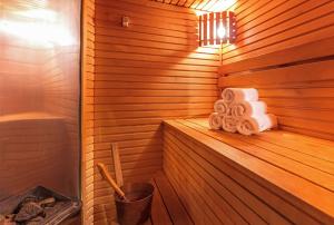 a sauna with a stack of towels on a shelf at Radisson Hotel Kaunas in Kaunas