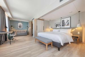 a hotel room with a large bed and a desk at Radisson Hotel Kaunas in Kaunas