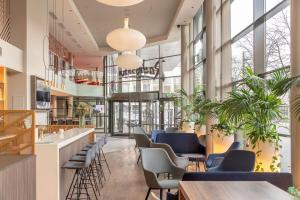 a lobby with blue chairs and tables and windows at Radisson Hotel Kaunas in Kaunas