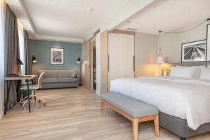 a hotel room with a large bed and a desk at Radisson Hotel Kaunas in Kaunas