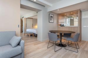 a living room with a table and chairs and a bed at Radisson Hotel Kaunas in Kaunas
