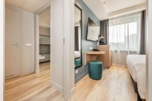 a bedroom with a bed and a table and a mirror at Radisson Hotel Kaunas in Kaunas