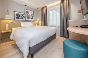 a hotel room with a large bed and a desk at Radisson Hotel Kaunas in Kaunas