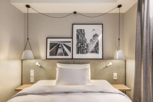 a bedroom with two pictures hanging above a bed at Radisson Hotel Kaunas in Kaunas