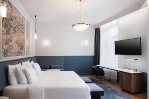 a hotel room with a bed and a desk at Radisson Collection Astorija Hotel, Vilnius in Vilnius