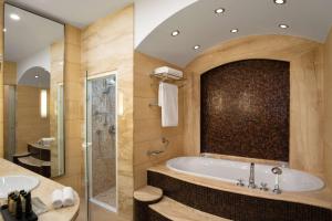 a large bathroom with a tub and a shower at Radisson Collection Astorija Hotel, Vilnius in Vilnius