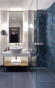 ヴィリニュスにあるRadisson Collection Astorija Hotel, Vilniusの洗面台とシャワー付きのバスルーム
