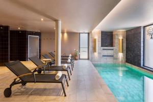 a pool with lounge chairs and a swimming pool at Aiden by Best Western T'aim Hotel in Compi&egrave;gne