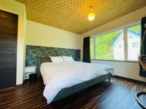 A bed or beds in a room at KIRAKU KAME Niseko2BDRM Royal emerald garden 2