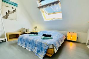ein Schlafzimmer mit einem Bett mit einer blauen Decke und einem Fenster in der Unterkunft Ti-vakañsoù - maison de vacances in Roscanvel