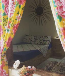 Cama pequeña en habitación con cortina en Pousada da Vivi, en Porto de Galinhas