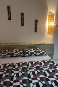 a bedroom with a bed with a quilt on it at Pousada da Vivi in Porto De Galinhas