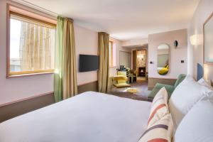 クレルモン・フェランにあるHôtel Aiden by Best Western Clermont-Ferrand - Le Magneticのベッドと窓が備わるホテルルーム