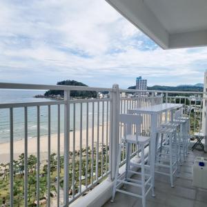 a balcony with chairs and a view of the beach at Yangyang Ocean Stay 환상적 전면 오션뷰 in Yangyang