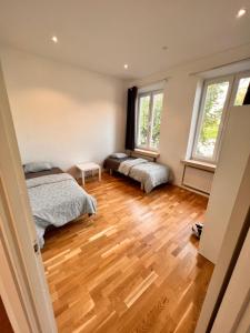 a bedroom with two beds and two windows at Husie Appartments in Malmö