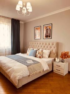 阿拉木圖的住宿－Уютная квартира в центре Алматы с потрясающими видами，一间卧室配有一张大床和一个吊灯。