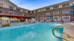 a pool in front of a hotel with chairs and umbrellas at Aiden by Best Western Scottsdale North in Scottsdale