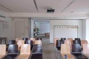 une salle de conférence avec des chaises et un tableau blanc en arrière-plan dans l'établissement Aiden by Best Western JHD Dunant Hotel, à Castiglione delle Stiviere