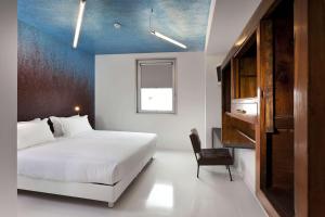 1 dormitorio con cama blanca y techo azul en Aiden by Best Western JHD Dunant Hotel, en Castiglione delle Stiviere