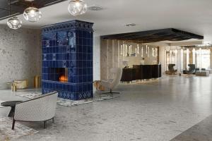 a lobby with a fireplace in the middle of a room at Radisson Blu Resort & Conference Center, Ostróda Mazury in Ostróda