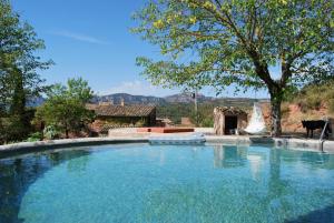 a large pool of water in front of a house at Masia Vilatersana in Sant Llorenc Savall