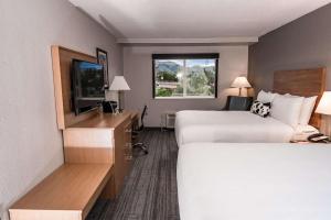 a hotel room with two beds and a flat screen tv at Aiden by Best Western Denver West Golden in Golden