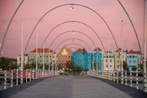 a bridge over a boardwalk in front of buildings at Brion City Hotel BW Signature Collection in Willemstad