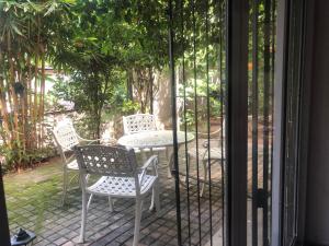 eine Terrasse mit 2 Stühlen, einem Tisch und einer Glastür in der Unterkunft Write Asia Hollidays in Gampaha