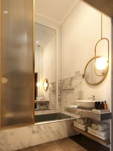 a bathroom with a sink and a large mirror at Cour des Loges Lyon, A Radisson Collection Hotel in Lyon