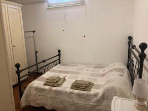 a bedroom with a bed with a blanket and a window at Appartamento con giardino a Selcetta vicino Campus Biomedico in Selcetta