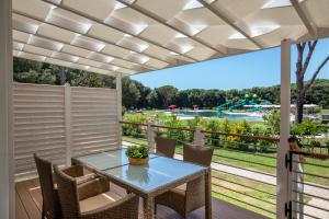 d'une terrasse avec une table et des chaises et une vue sur un parc. dans l'établissement Parco Della Gallinara, à Lido dei Pini