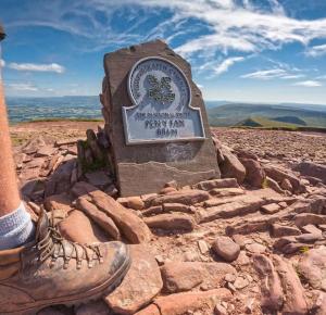 a sign on top of a mountain with a persons shoe at Mountain View Cottage sleep 6 sofabed quaint and quirky cottage in Ystalyfera