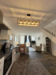 a kitchen with a table and a dining room at Mountain View Cottage sleep 6 sofabed quaint and quirky cottage in Ystalyfera