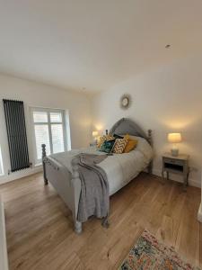 a bedroom with a bed and a wooden floor at Mountain View Cottage sleep 6 sofabed quaint and quirky cottage in Ystalyfera