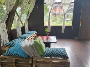 um quarto com duas camas, uma mesa e janelas em Aubrey Villa Ciwidey em Pengalongan