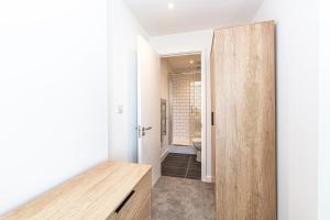 um corredor com uma porta que leva a uma casa de banho em Insignia Apartments em Manchester