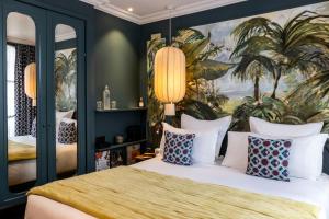 a bedroom with a large bed with a painting on the wall at Hôtel Monte Cristo in Paris +66 photos