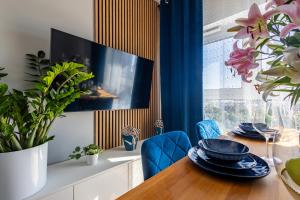 uma sala de jantar com uma mesa de madeira e cadeiras azuis em Apartamenty we Wrocławiu - Jaworska em Breslávia
