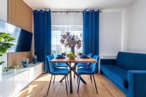 comedor con mesa y sillas azules en Apartamenty we Wrocławiu - Jaworska - MAMY WOLNE POKOJE !, en Wroclaw