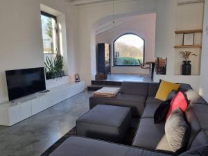 sala de estar con sofá y TV de pantalla plana en Historische Villa mit Garten, Luxus, en Meerbusch
