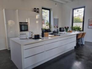 a large white kitchen with a large counter top at Historische Villa mit Garten, Luxus in Meerbusch
