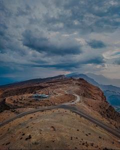 a winding road on the side of a mountain at Shorfet Al Alamin Hotel in Al Ḩamrāʼ