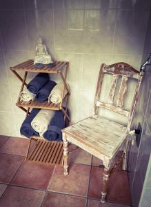een badkamer met een stoel en een plank met handdoeken bij Modernes Appartement im Grünen in Keulen